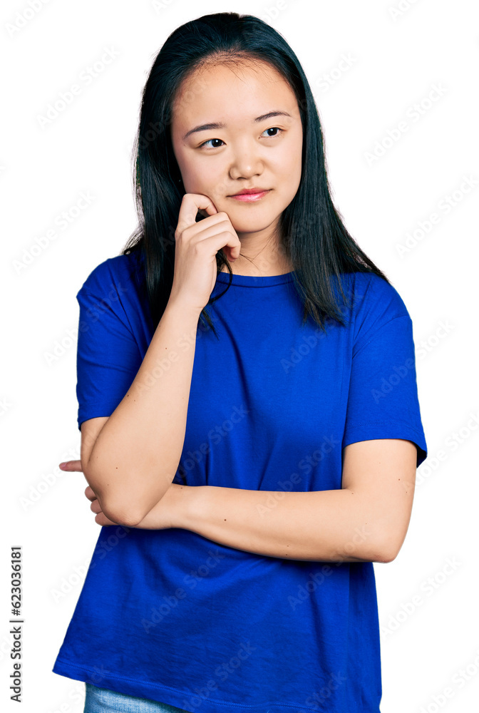 Young chinese woman wearing casual blue t shirt thinking concentrated about doubt with finger on chin and looking up wondering Young chinese woman wearing casual blue t shirt thinking concentrated about doubt with finger on chin and looking up wondering