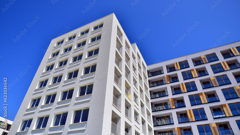 Fototapeta premium Contemporary residential building exterior in the daylight. Modern apartment buildings on a sunny day with a blue sky. Facade of a modern apartment building. 