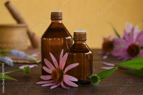 Fragrant medical tincture of Echinacea purpurea in a glass bottles. Concrept of Herbal or homeopathy medicine. Flower essential oil. Herbal medicine. Side view.
