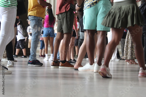 A photo of a group of people congregating in one spot on a marble floor. 