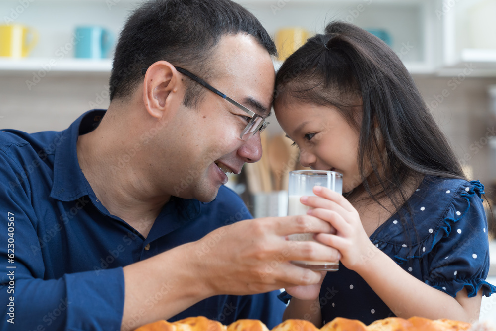 Happy Asian father and daughter in kitchen at home. Happy Asian family spending time together in kitchen at home Happy Asian father and daughter in kitchen at home. Happy Asian family spending time together in kitchen at home