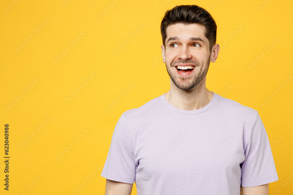 Young surprised shocked excited happy caucasian man wear light purple t-shirt casual clothes look aside on workspace area mock up isolated on plain yellow background studio portrait Lifestyle concept Young surprised shocked excited happy caucasian man wear light purple t-shirt casual clothes look aside on workspace area mock up isolated on plain yellow background studio portrait Lifestyle concept