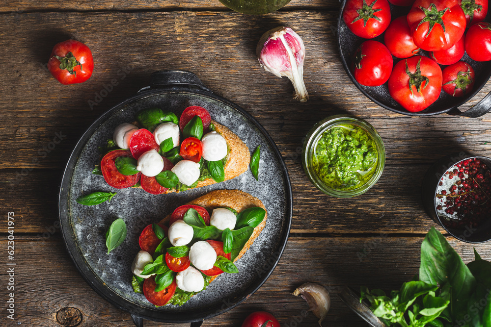 Bruschetta with mozzarella, tomatoes, basil and pesto in a plate. Bruschetta Caprese