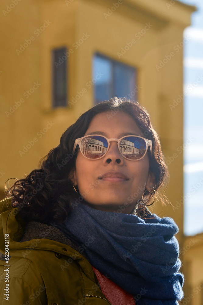 Close-up of the face of a black woman with sunglasses, where an old medieval building is reflected Close-up of the face of a black woman with sunglasses, where an old medieval building is reflected