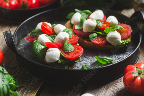 Bruschetta with mozzarella  tomatoes  basil and pesto in a plate. Bruschetta Caprese