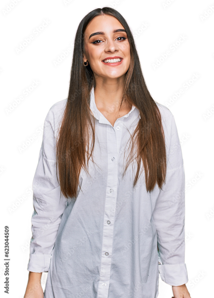 Young beautiful woman wearing casual white shirt looking positive and happy standing and smiling with a confident smile showing teeth Young beautiful woman wearing casual white shirt looking positive and happy standing and smiling with a confident smile showing teeth