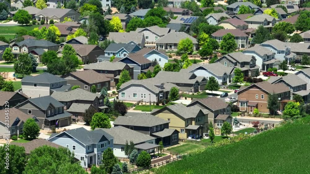 Quaint neighborhood in summer. Aerial parallax shot of new homes in housing development next to agricultural corn field. USA houses. Quaint neighborhood in summer. Aerial parallax shot of new homes in housing development next to agricultural corn field. USA houses.