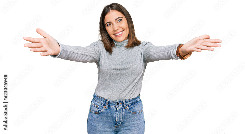 Young beautiful woman wearing casual turtleneck sweater smiling cheerful offering hands giving assistance and acceptance. Young beautiful woman wearing casual turtleneck sweater smiling cheerful offering hands giving assistance and acceptance.