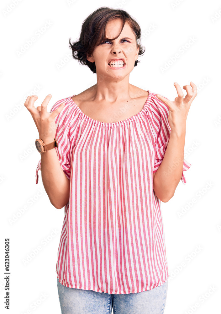 Beautiful young woman with short hair wearing casual summer clothes crazy and mad shouting and yelling with aggressive expression and arms raised. frustration concept. Beautiful young woman with short hair wearing casual summer clothes crazy and mad shouting and yelling with aggressive expression and arms raised. frustration concept.