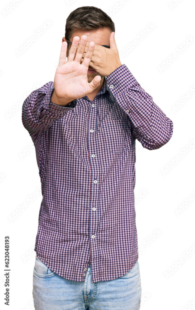 Handsome caucasian man wearing casual clothes and glasses covering eyes with hands and doing stop gesture with sad and fear expression. embarrassed and negative concept. Handsome caucasian man wearing casual clothes and glasses covering eyes with hands and doing stop gesture with sad and fear expression. embarrassed and negative concept.