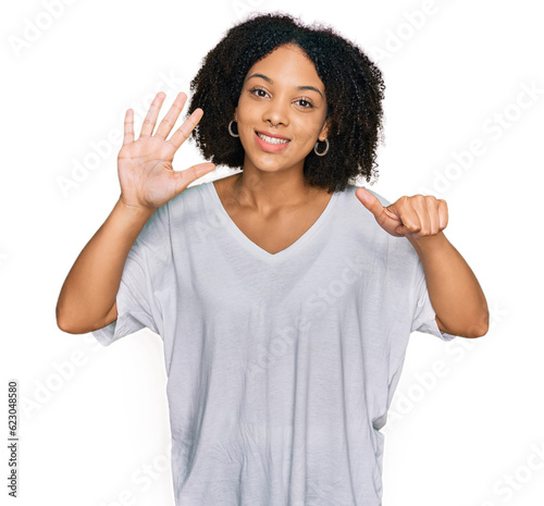 Young african american girl wearing casual clothes showing and pointing up with fingers number six while smiling confident and happy.