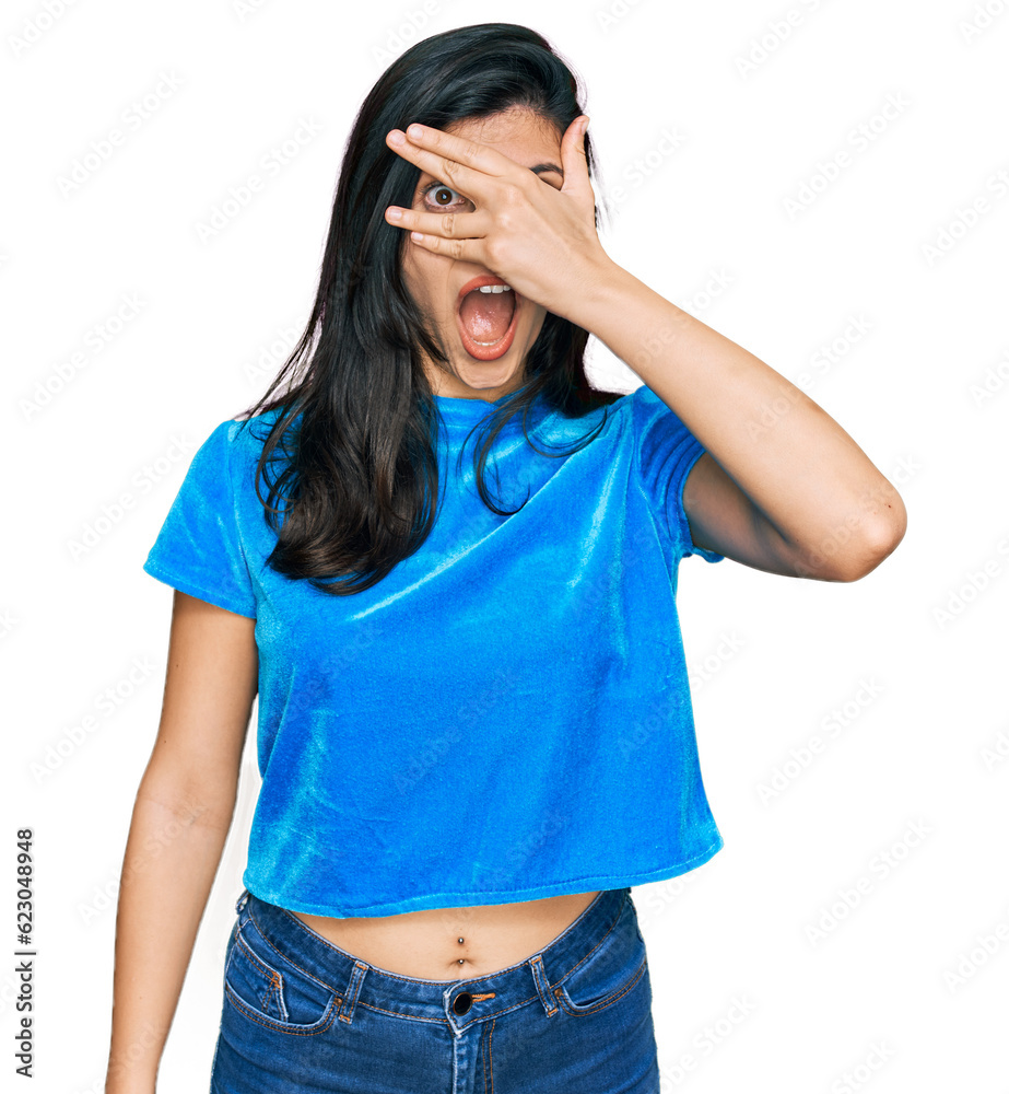 Young hispanic woman wearing casual clothes peeking in shock covering face and eyes with hand, looking through fingers with embarrassed expression. Young hispanic woman wearing casual clothes peeking in shock covering face and eyes with hand, looking through fingers with embarrassed expression.