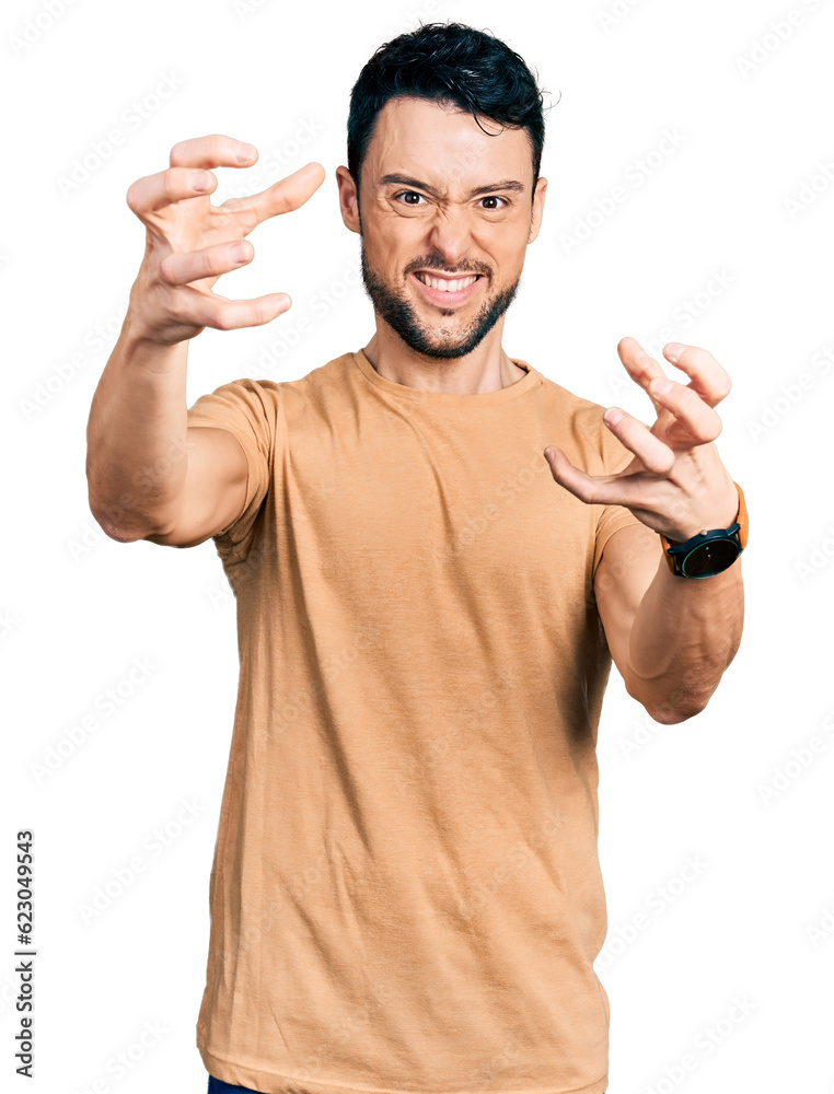 Fototapeta premium Hispanic man with beard wearing casual t shirt shouting frustrated with rage, hands trying to strangle, yelling mad