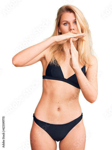 Young beautiful blonde woman wearing bikini doing time out gesture with hands, frustrated and serious face © Krakenimages.com