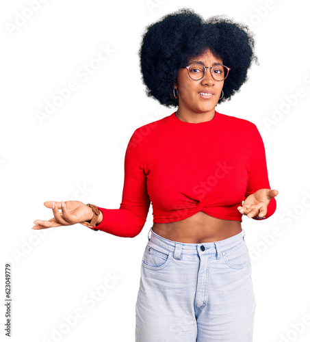 Young african american girl wearing casual clothes and glasses clueless and confused with open arms, no idea concept.