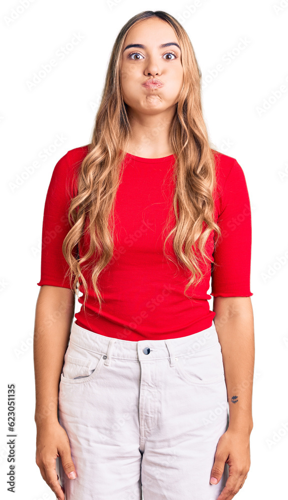 Young beautiful blonde woman wearing casual clothes puffing cheeks with funny face. mouth inflated with air, crazy expression. Young beautiful blonde woman wearing casual clothes puffing cheeks with funny face. mouth inflated with air, crazy expression.