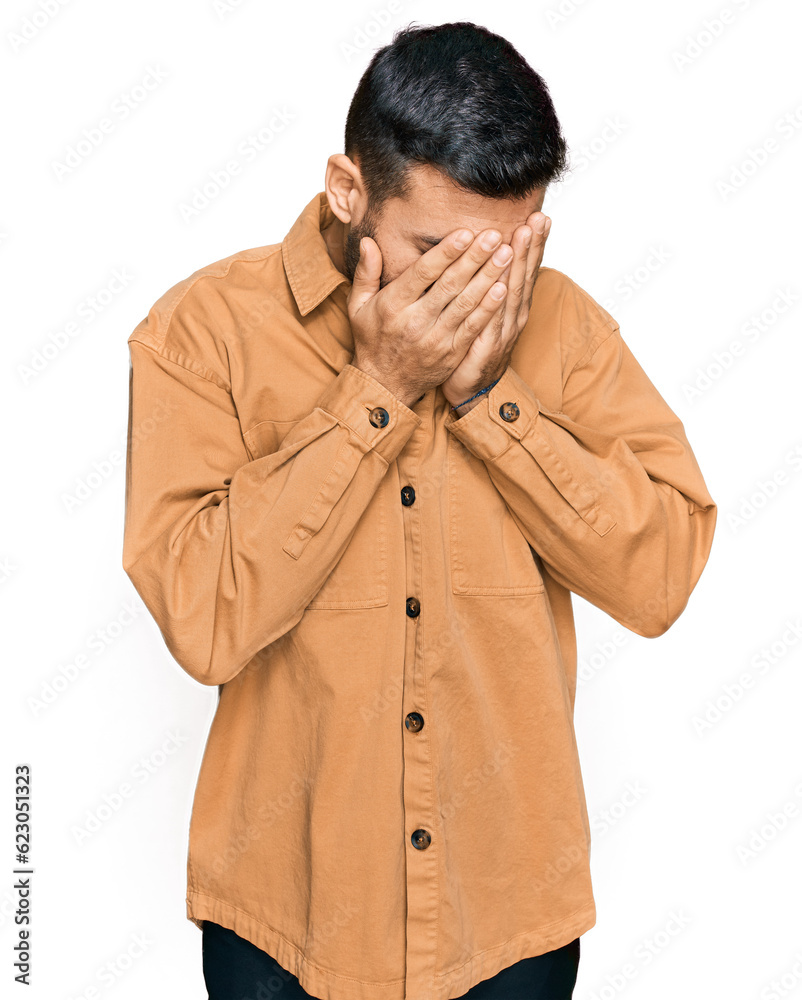 Young hispanic man wearing casual clothes with sad expression covering face with hands while crying. depression concept. Young hispanic man wearing casual clothes with sad expression covering face with hands while crying. depression concept.