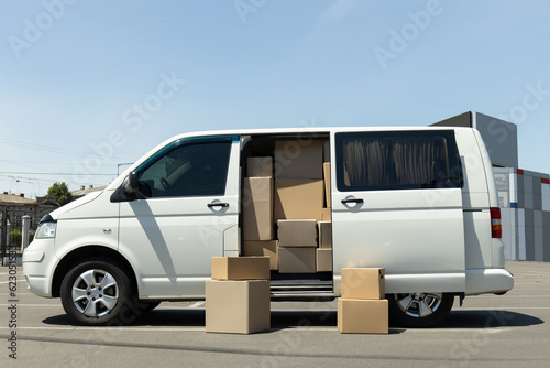 A white delivery service car with boxes inside