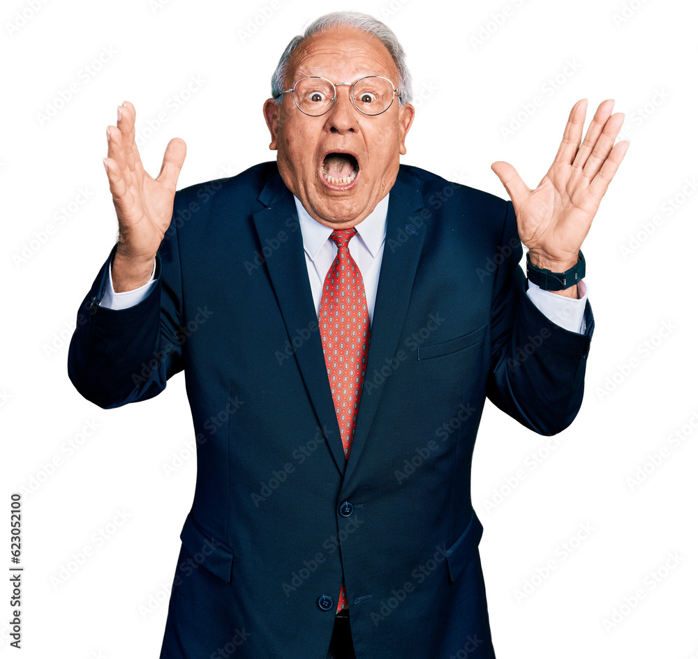 Senior man with grey hair wearing business suit and glasses celebrating crazy and amazed for success with arms raised and open eyes screaming excited. winner concept Senior man with grey hair wearing business suit and glasses celebrating crazy and amazed for success with arms raised and open eyes screaming excited. winner concept
