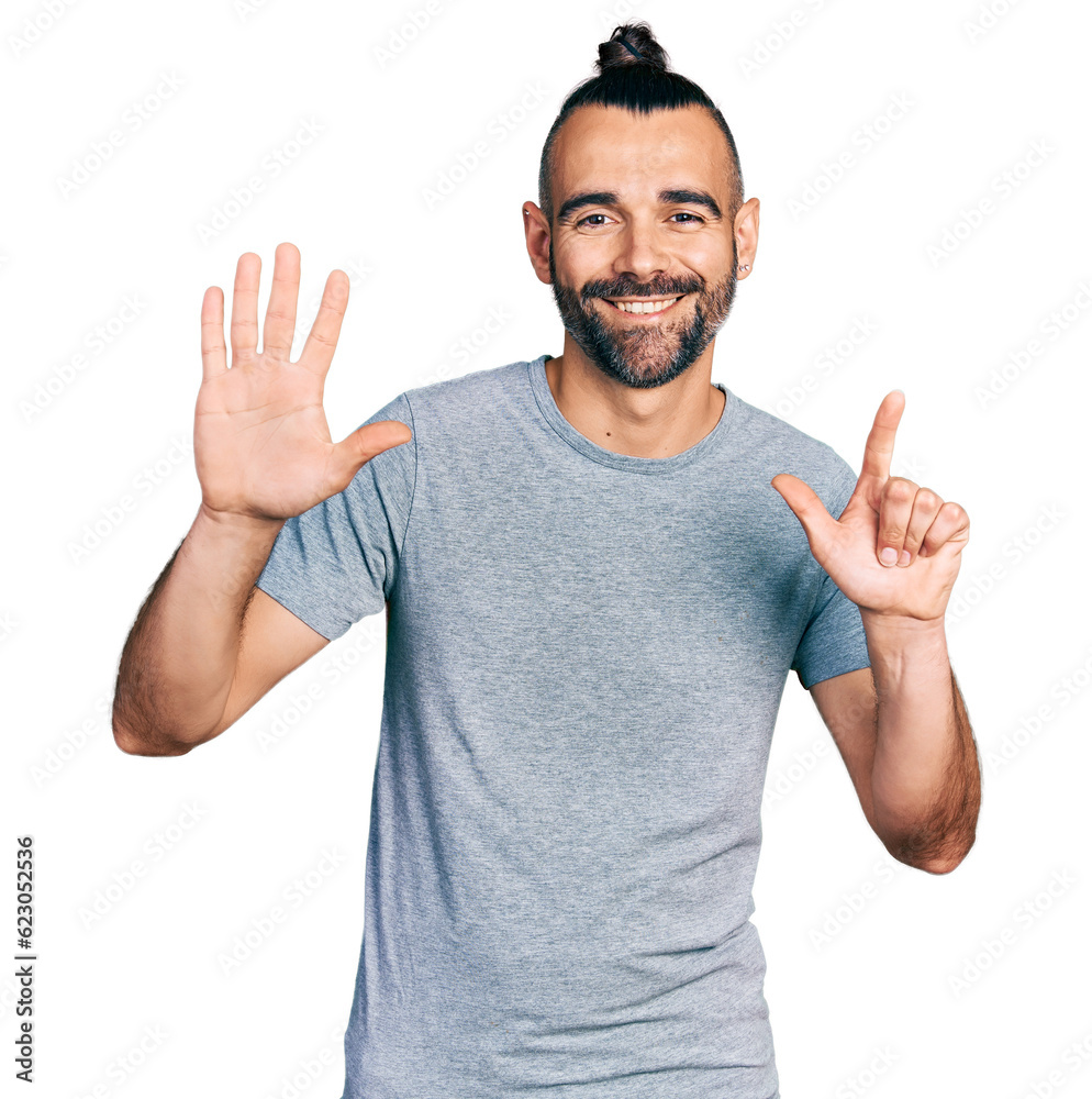 Hispanic man with ponytail wearing casual grey t shirt showing and pointing up with fingers number seven while smiling confident and happy. Hispanic man with ponytail wearing casual grey t shirt showing and pointing up with fingers number seven while smiling confident and happy.