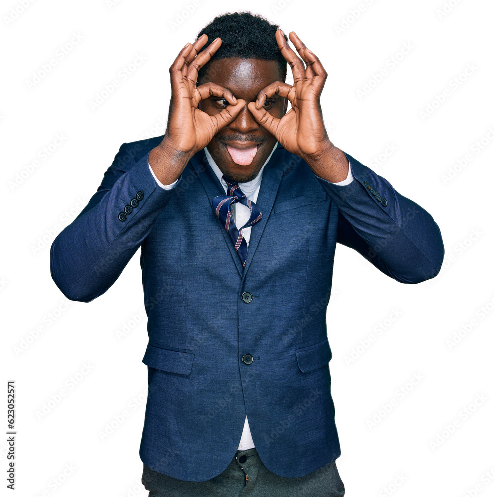 Handsome business black man wearing business suit and tie doing ok gesture like binoculars sticking tongue out, eyes looking through fingers. crazy expression. Handsome business black man wearing business suit and tie doing ok gesture like binoculars sticking tongue out, eyes looking through fingers. crazy expression.