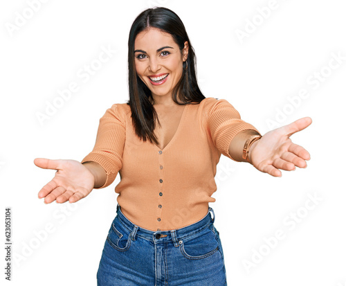 Young hispanic woman wearing casual clothes smiling cheerful offering hands giving assistance and acceptance.