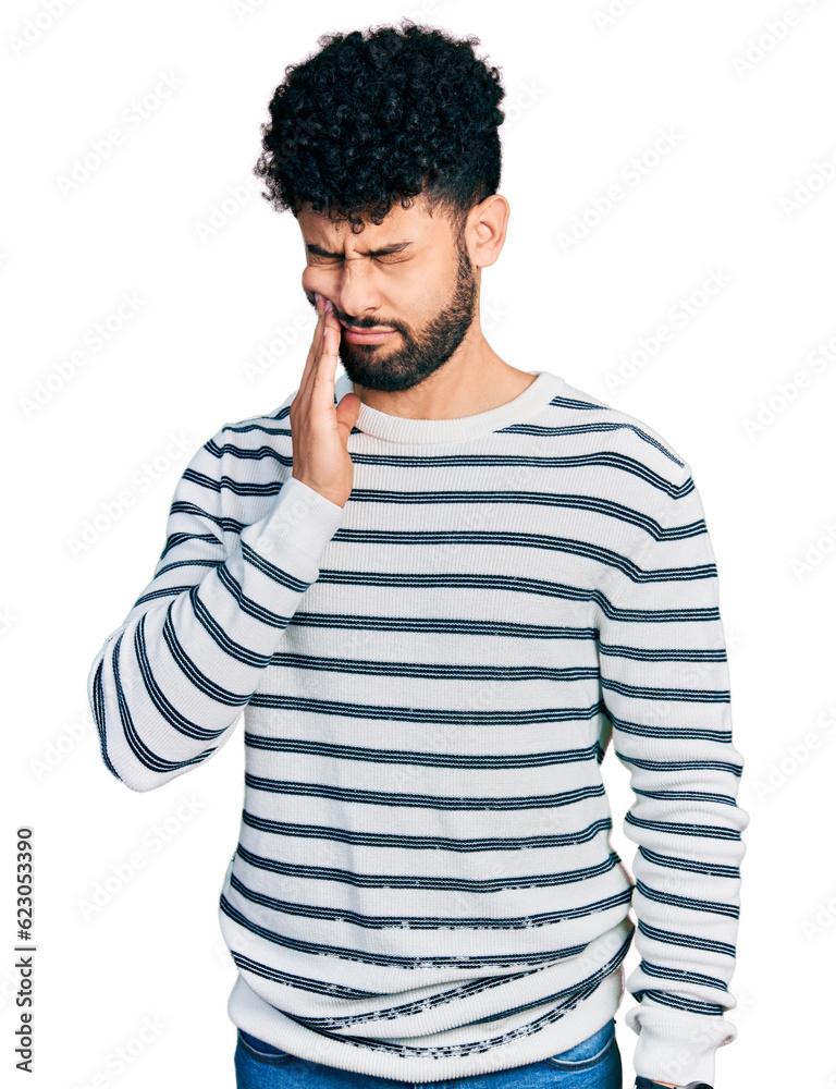Young arab man with beard wearing casual striped sweater touching mouth with hand with painful expression because of toothache or dental illness on teeth. dentist Young arab man with beard wearing casual striped sweater touching mouth with hand with painful expression because of toothache or dental illness on teeth. dentist