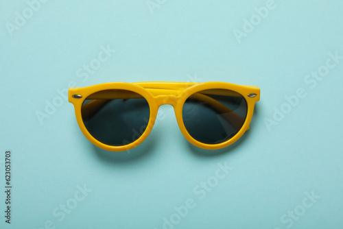 Sunglasses on a blue background, top view
