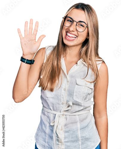Hispanic young woman wearing casual white shirt showing and pointing up with fingers number five while smiling confident and happy.