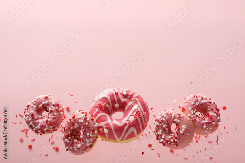 Pink donuts levitate in the air on a pink background