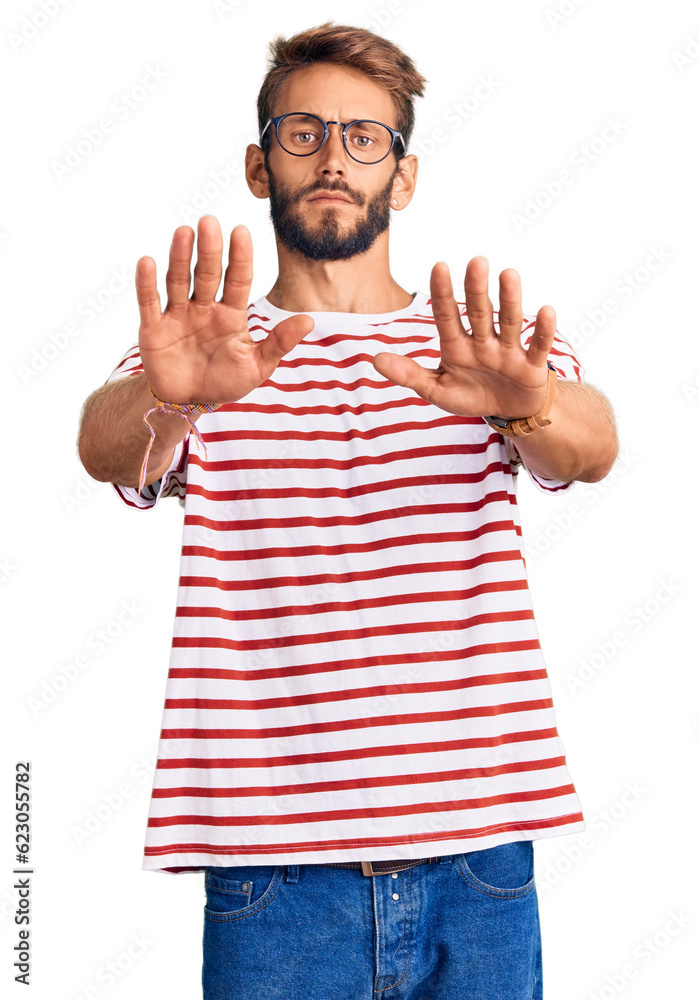 Handsome blond man with beard wearing casual clothes and glasses doing stop gesture with hands palms, angry and frustration expression Handsome blond man with beard wearing casual clothes and glasses doing stop gesture with hands palms, angry and frustration expression