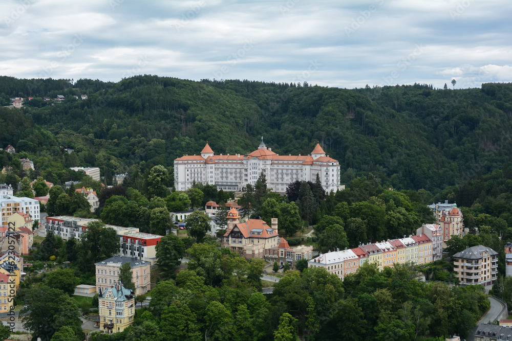 Beautiful colorful buildings in traditional spa town of Karlovy Vary, Czech Republic. Traditional buildings of Karlovy Vary, bird's eye panorama with the hills in the background.