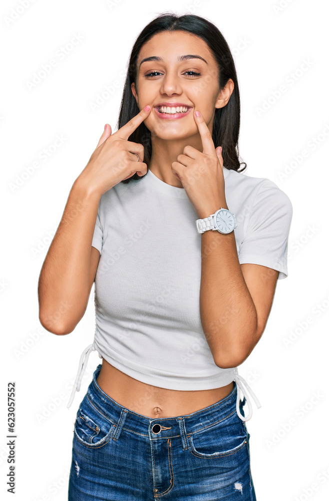 Young hispanic girl wearing casual white t shirt smiling with open mouth, fingers pointing and forcing cheerful smile Young hispanic girl wearing casual white t shirt smiling with open mouth, fingers pointing and forcing cheerful smile