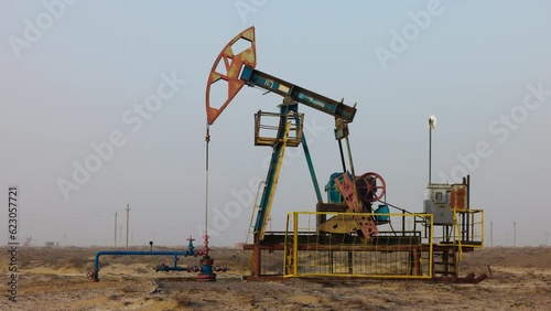 Oil industry, Pumping petroleum Rig in desert. Pump Jack Extracting Crude Oil from a Oil Well. Fossil Fuel Energy. Working oil pump jacks