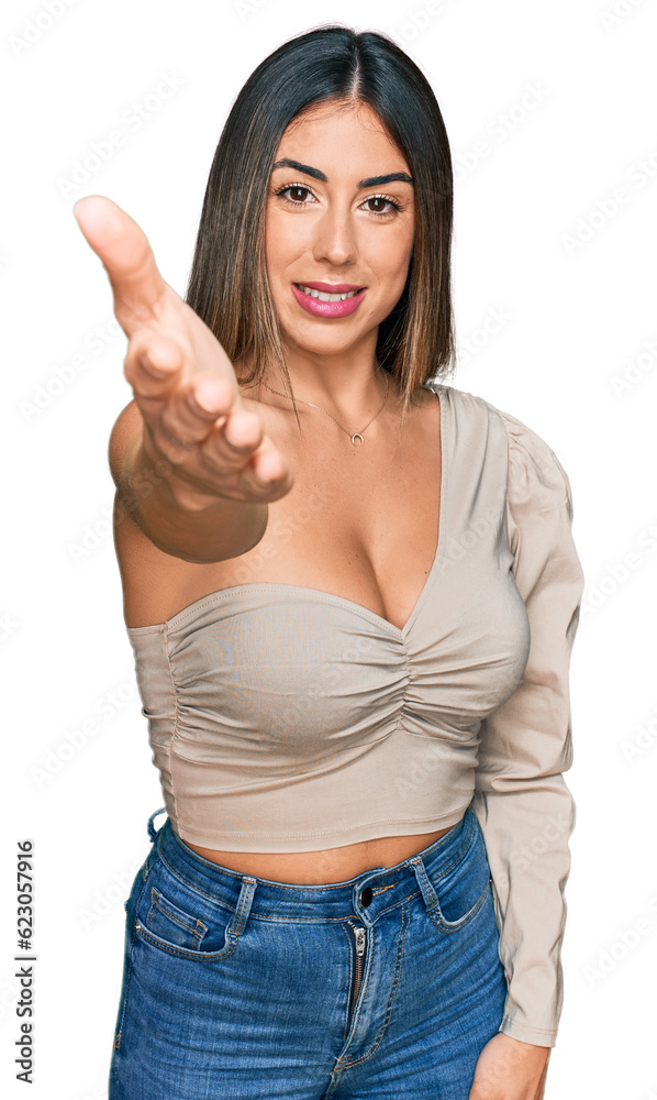 Young hispanic woman wearing casual clothes smiling friendly offering handshake as greeting and welcoming. successful business. Young hispanic woman wearing casual clothes smiling friendly offering handshake as greeting and welcoming. successful business.