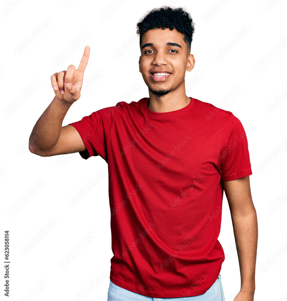 Young african american man wearing casual red t shirt showing and pointing up with finger number one while smiling confident and happy. Young african american man wearing casual red t shirt showing and pointing up with finger number one while smiling confident and happy.