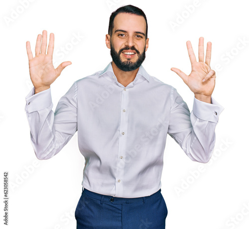 Young man with beard wearing business shirt showing and pointing up with fingers number nine while smiling confident and happy. © Krakenimages.com