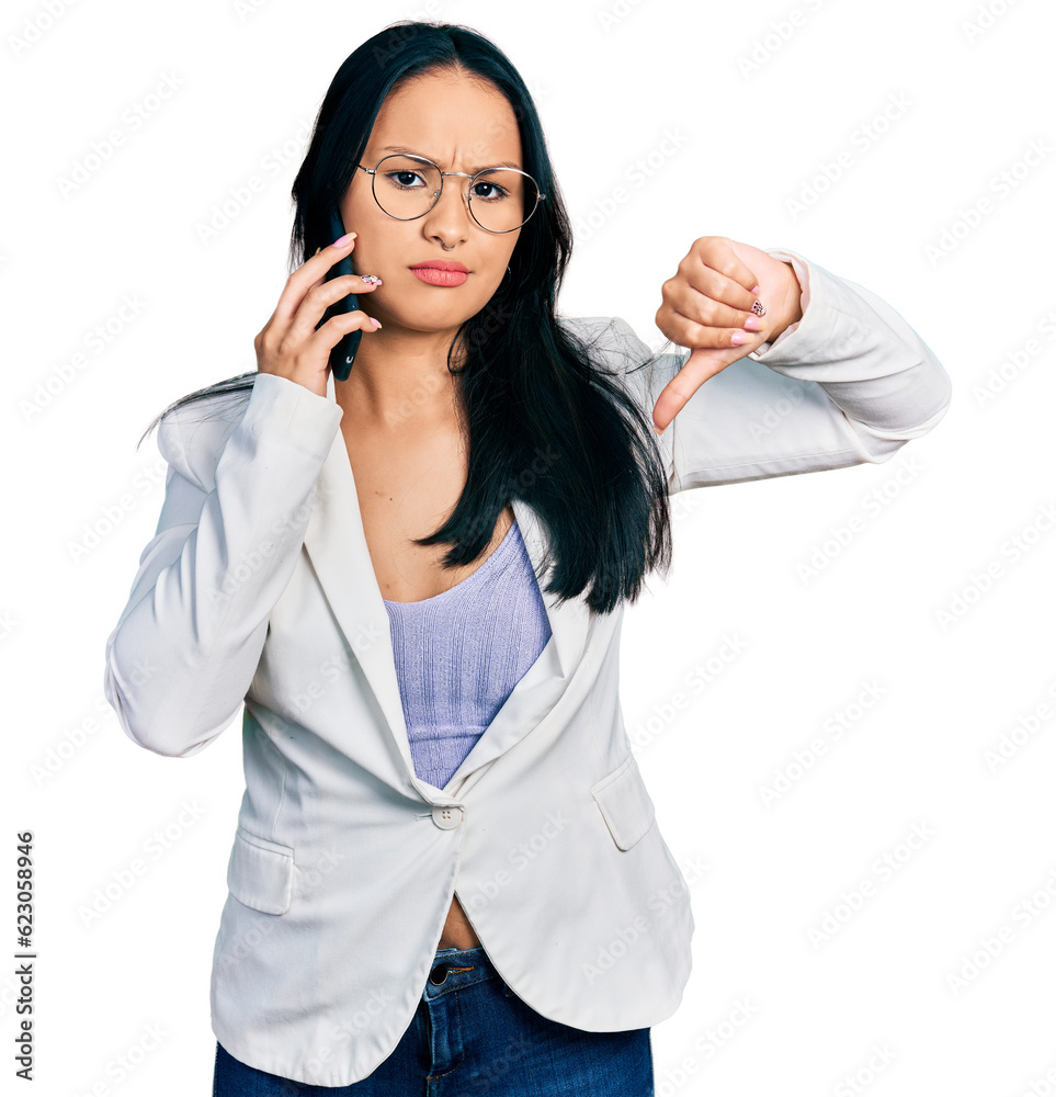 Beautiful hispanic woman with nose piercing having conversation talking on the smartphone with angry face, negative sign showing dislike with thumbs down, rejection concept Beautiful hispanic woman with nose piercing having conversation talking on the smartphone with angry face, negative sign showing dislike with thumbs down, rejection concept