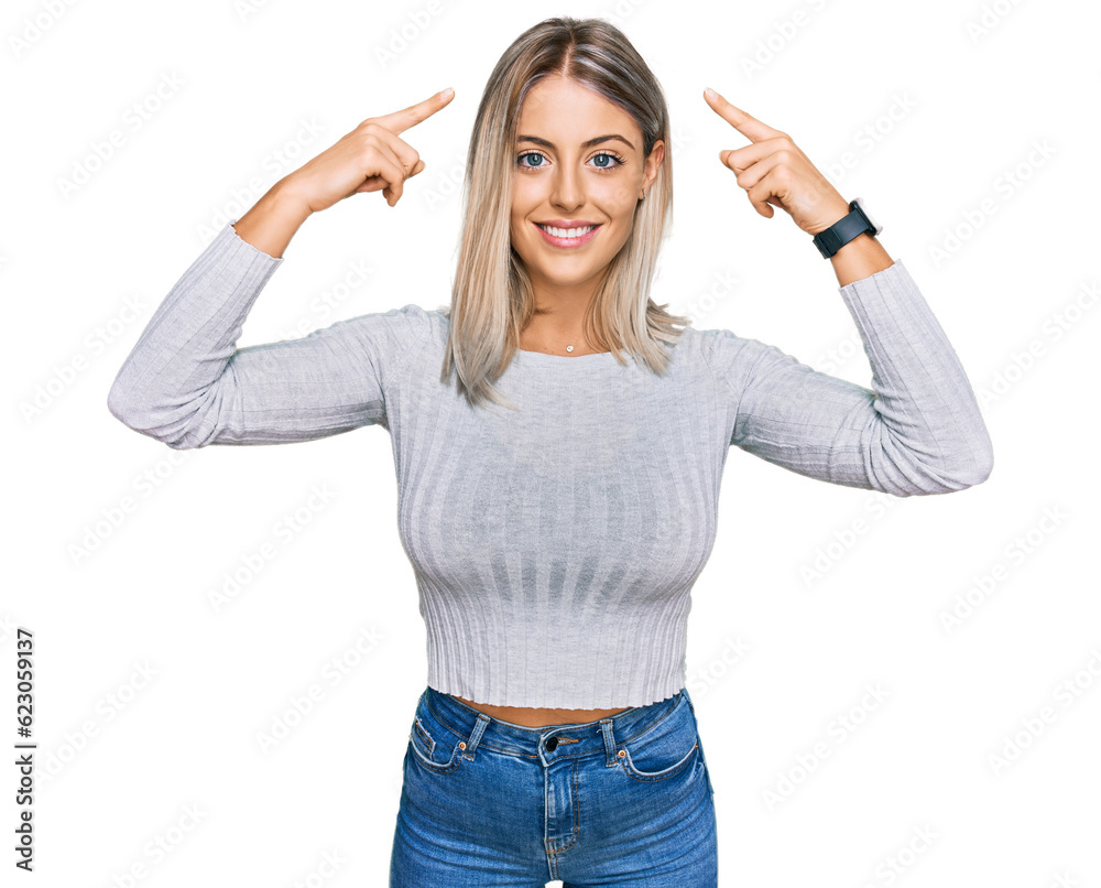 Beautiful blonde woman wearing casual clothes smiling pointing to head with both hands finger, great idea or thought, good memory Beautiful blonde woman wearing casual clothes smiling pointing to head with both hands finger, great idea or thought, good memory