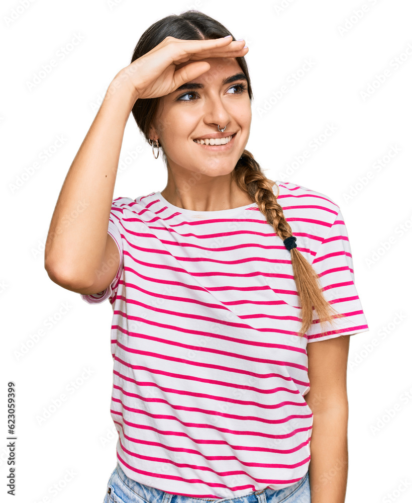 Young hispanic woman wearing casual clothes very happy and smiling looking far away with hand over head. searching concept.