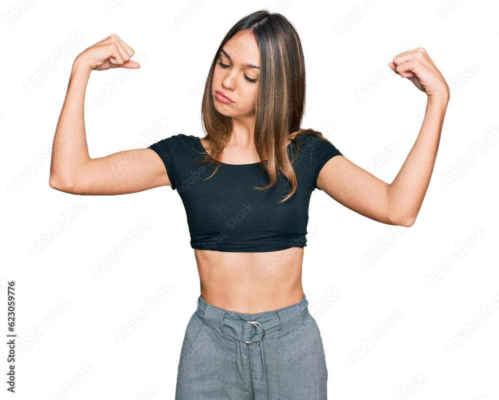 Young brunette woman wearing casual clothes showing arms muscles smiling proud. fitness concept. Young brunette woman wearing casual clothes showing arms muscles smiling proud. fitness concept.
