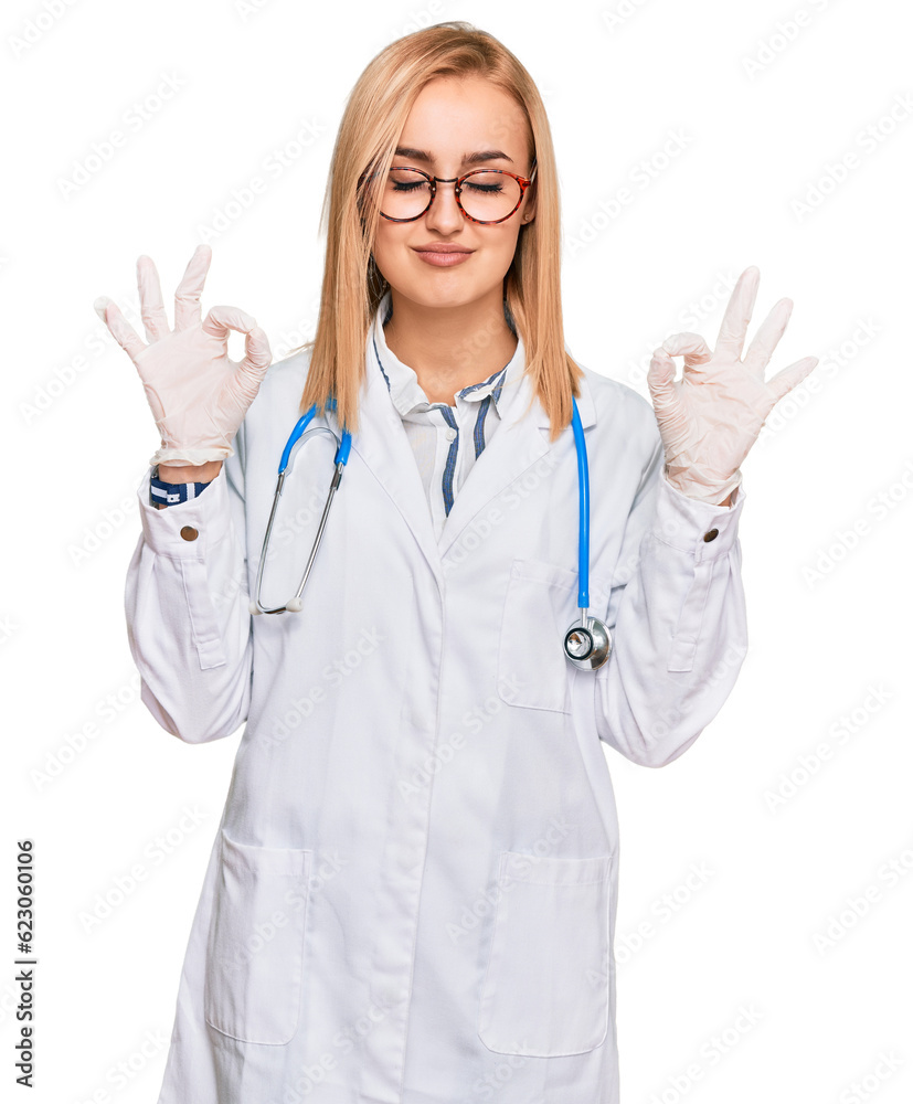 Beautiful caucasian woman wearing doctor uniform and stethoscope relax and smiling with eyes closed doing meditation gesture with fingers. yoga concept. Beautiful caucasian woman wearing doctor uniform and stethoscope relax and smiling with eyes closed doing meditation gesture with fingers. yoga concept.