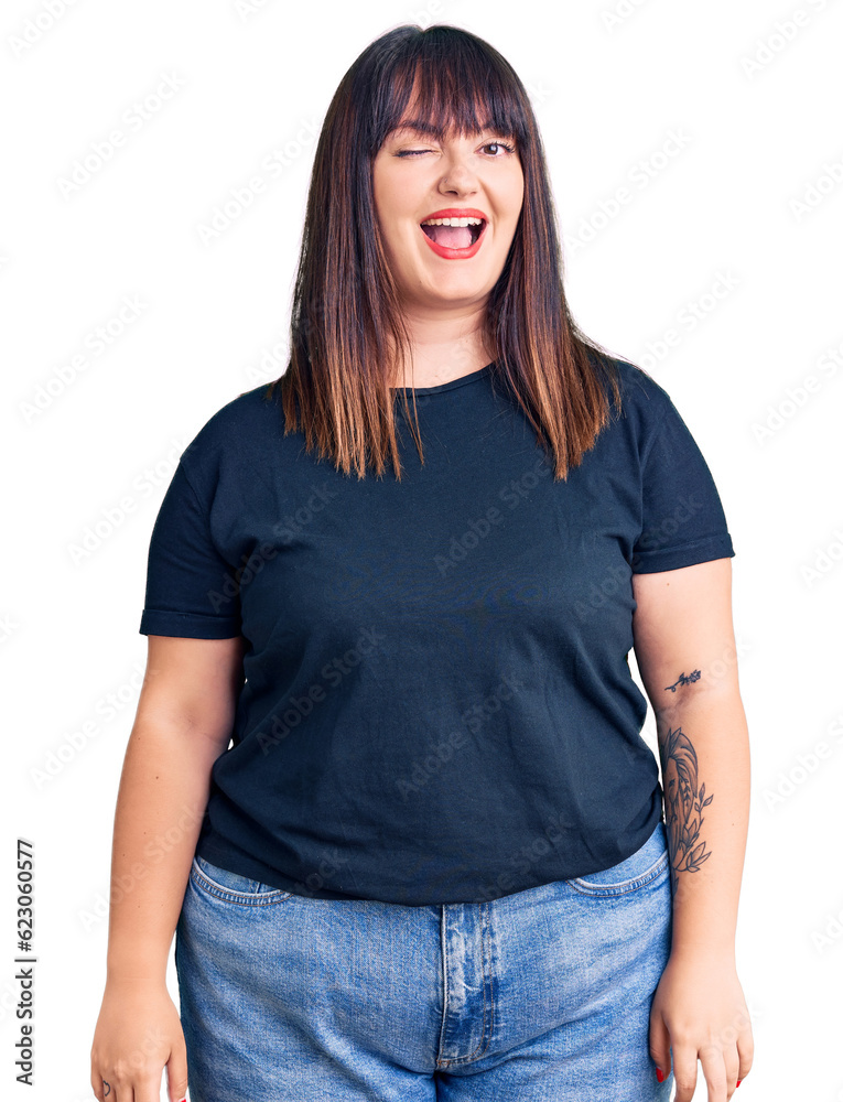 Young plus size woman wearing casual clothes winking looking at the camera with sexy expression, cheerful and happy face. Young plus size woman wearing casual clothes winking looking at the camera with sexy expression, cheerful and happy face.