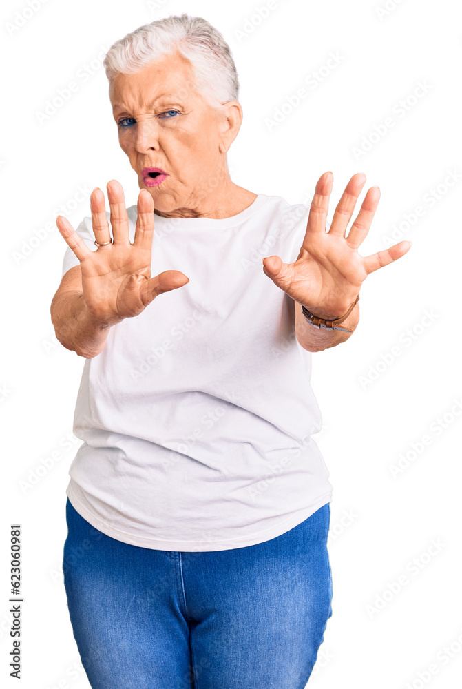Senior beautiful woman with blue eyes and grey hair wearing casual white tshirt doing stop gesture with hands palms, angry and frustration expression Senior beautiful woman with blue eyes and grey hair wearing casual white tshirt doing stop gesture with hands palms, angry and frustration expression