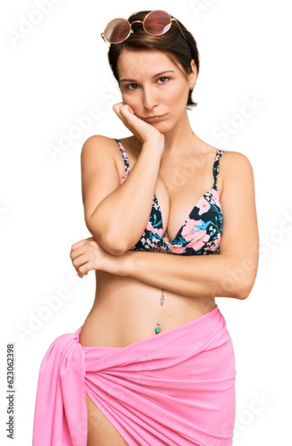 Young brunette woman with short hair wearing bikini thinking looking tired and bored with depression problems with crossed arms.