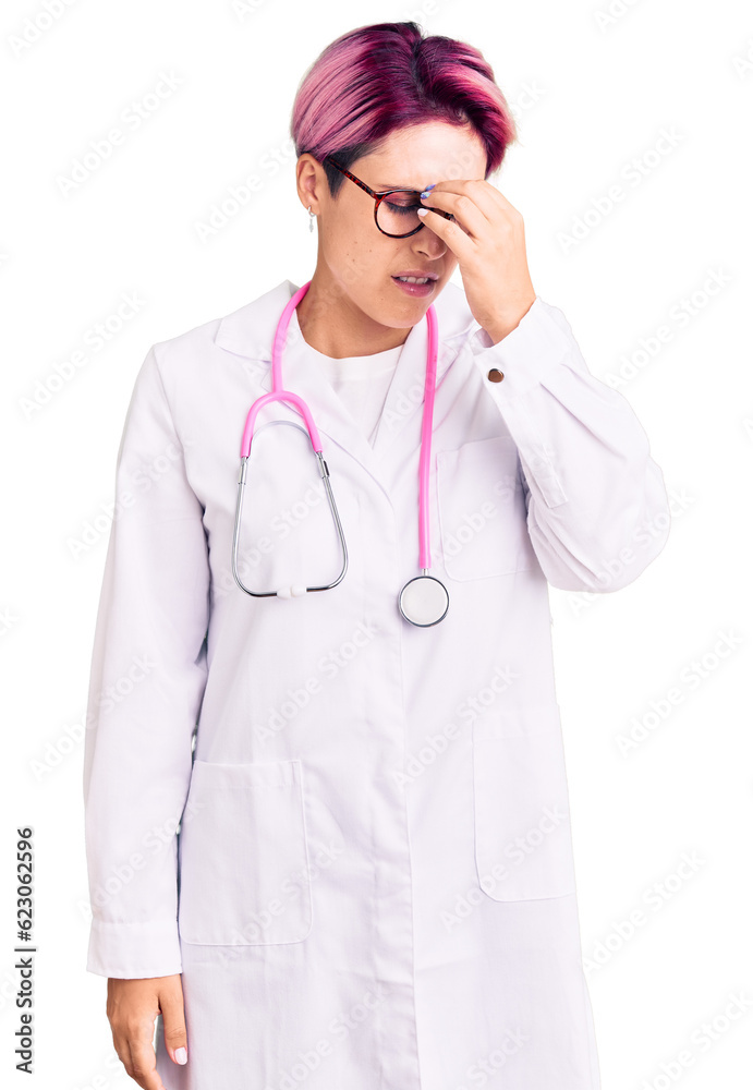 Young beautiful woman with pink hair wearing doctor uniform tired rubbing nose and eyes feeling fatigue and headache. stress and frustration concept. Young beautiful woman with pink hair wearing doctor uniform tired rubbing nose and eyes feeling fatigue and headache. stress and frustration concept.
