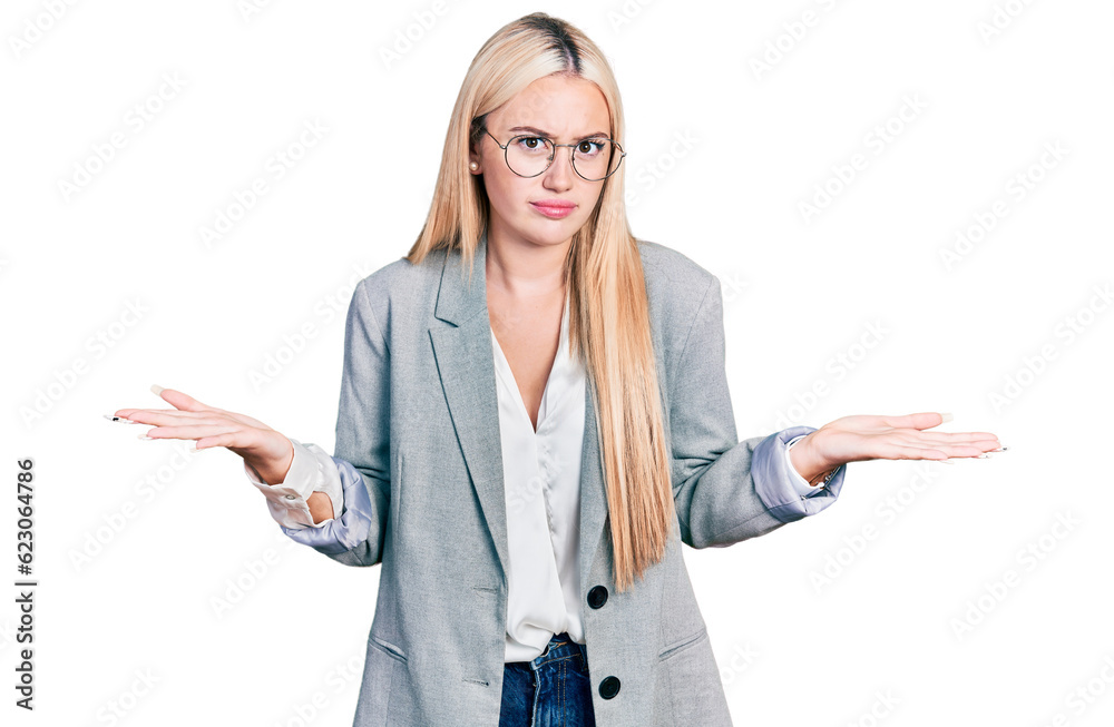 Beautiful blonde woman wearing business jacket and glasses clueless and confused expression with arms and hands raised. doubt concept. Beautiful blonde woman wearing business jacket and glasses clueless and confused expression with arms and hands raised. doubt concept.
