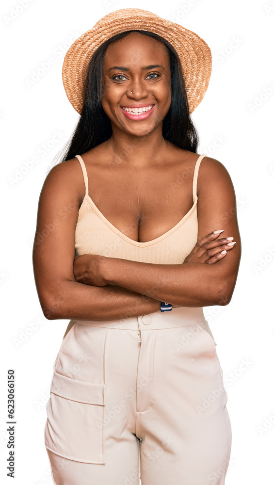 Young black woman wearing summer hat happy face smiling with crossed arms looking at the camera. positive person. Young black woman wearing summer hat happy face smiling with crossed arms looking at the camera. positive person.
