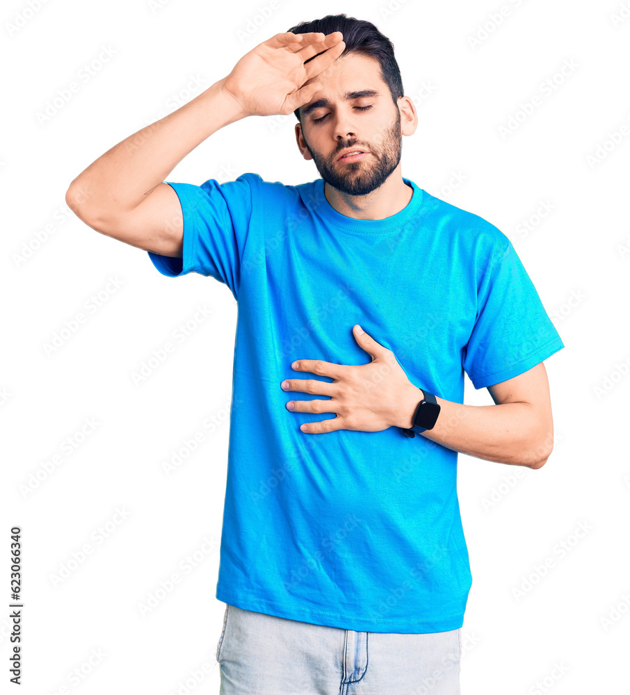 Young handsome man with beard wearing casual t-shirt touching forehead for illness and fever, flu and cold, virus sick Young handsome man with beard wearing casual t-shirt touching forehead for illness and fever, flu and cold, virus sick