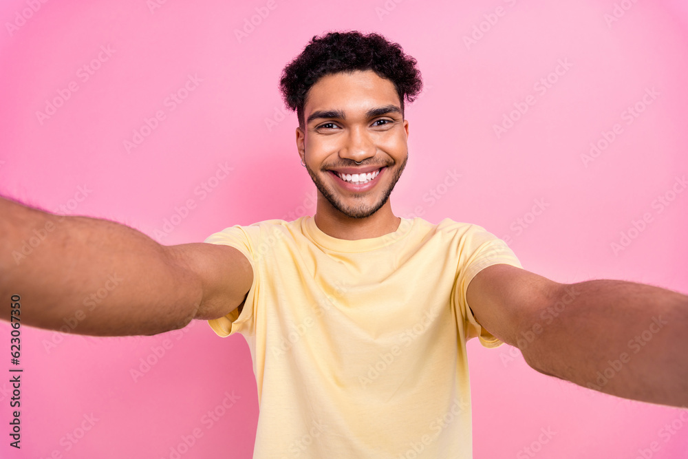 Photo of handsome cheerful pleasant guy wear stylish yellow t-shirt making selfie record video for blog isolated on pink color background Photo of handsome cheerful pleasant guy wear stylish yellow t-shirt making selfie record video for blog isolated on pink color background